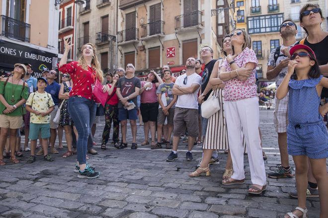 A tour guide is showing something to a group of travelers during a free walking tour in Pamplona with GuruWalk.