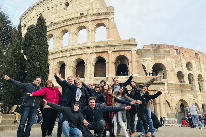 Guía de free tour con su grupo frente al Coliseo de Roma, Italia.