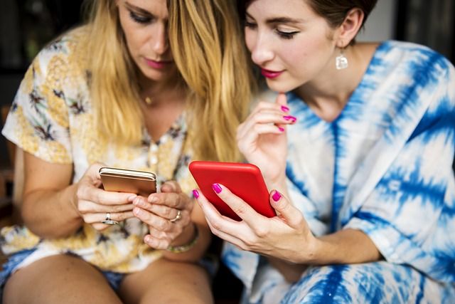 Two travelers looking at their mobile phones.